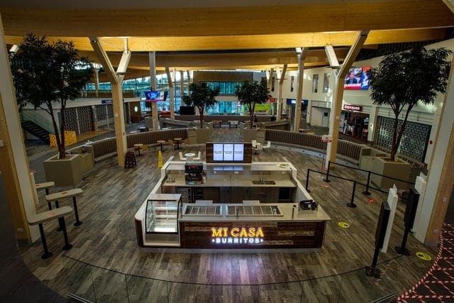 An empty food court with a "mi casa burritos" stand.