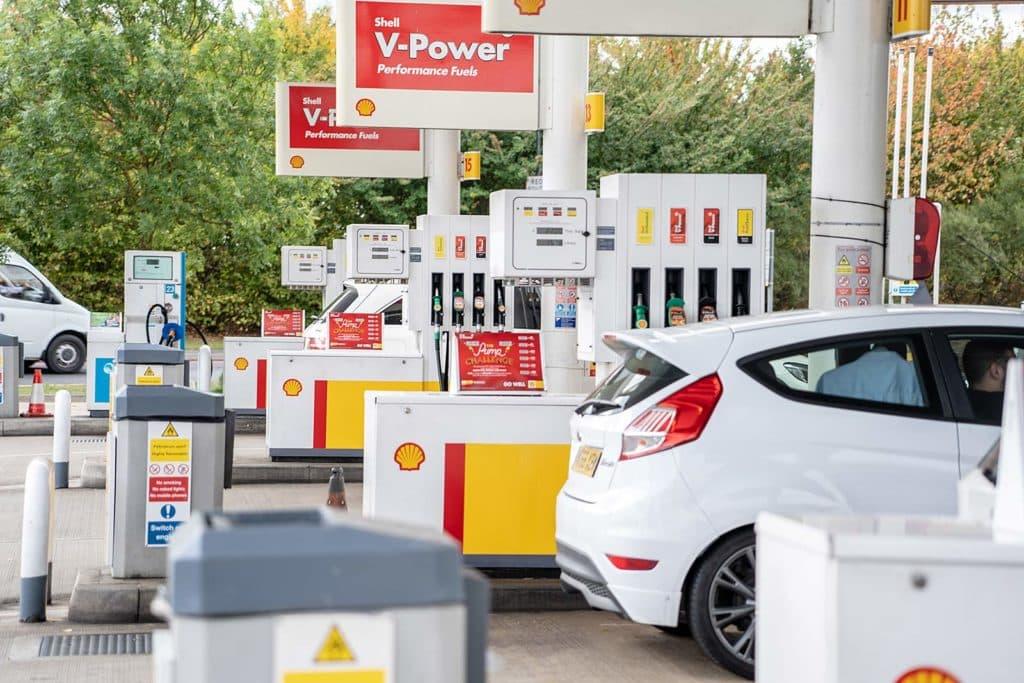 Vehicles refueling at a Motorway Service Area shell gas station with v-power performance fuels branding.